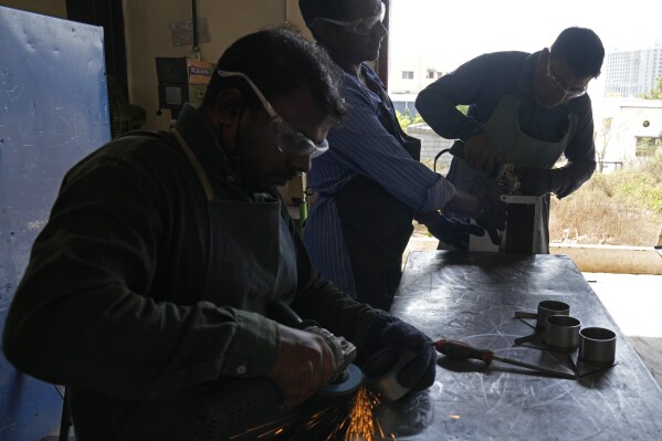 Workers use machines to finish the steel products manufactured at a factory in a suburb of Bengaluru, India, Thursday, Feb. 27, 2025. (AP Photo/Aijaz Rahi)